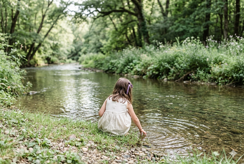 Petite fille au bord d'une rivière : illustration pour le roman Naïa de Gabrielle Baptiste.