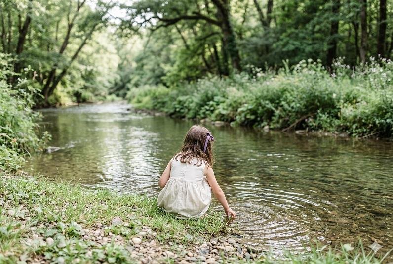 Petite fille au bord d'une rivière : illustration pour le roman Naïa de Gabrielle Baptiste